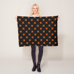 Orange cross stitches on black fleece blanket