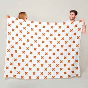 Orange cross stitches on white fleece blanket