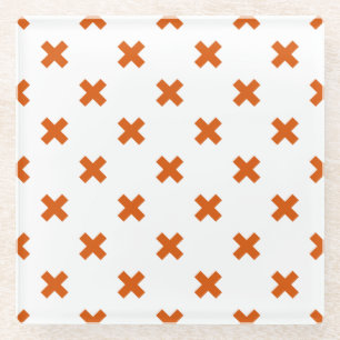 Orange cross stitches on white glass coaster