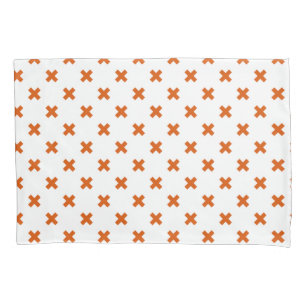 Orange cross stitches on white pillowcase