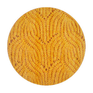 Orange knitted sweater, textured background. cutting board