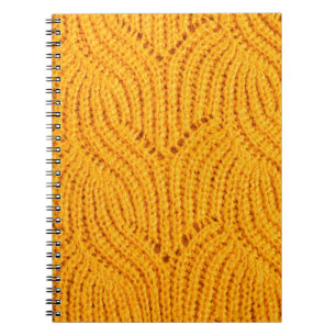 Orange knitted sweater, textured background. notebook