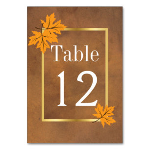 Orange maple leaves on brown wedding table number