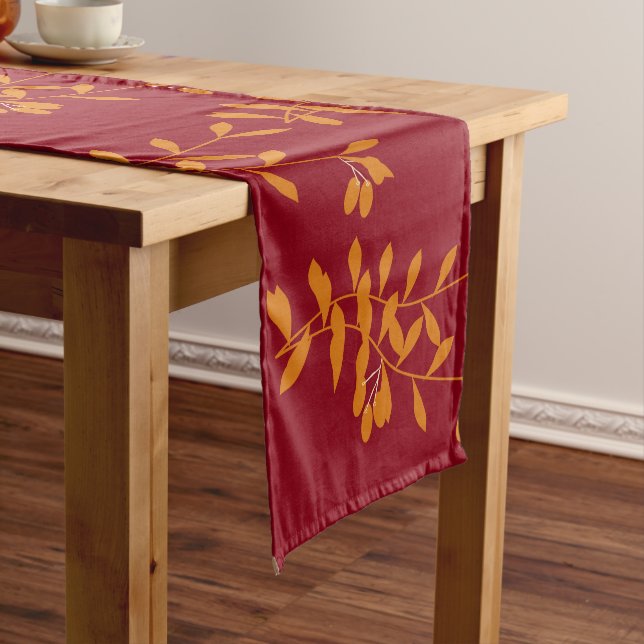 Orange silhouette branch leaves on red short table runner (In Situ)