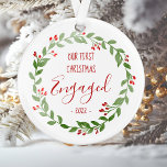 Our First Christmas Engaged Custom Photo Wreath Ornament<br><div class="desc">Celebrate your first Christmas together as an engaged couple with this keepsake ornament, featuring a rustic watercolor Christmas wreath surrounding the words "Our First Christmas Engaged" and the year in whimsical red printing and handwriting fonts. Customize the reverse side with your favorite photo of the two of you, encircled by...</div>