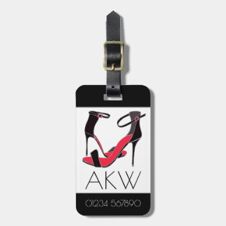 Pair of high heeled shoes on black with monogram luggage tag