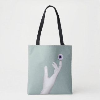 Pale hand holding eye tote bag