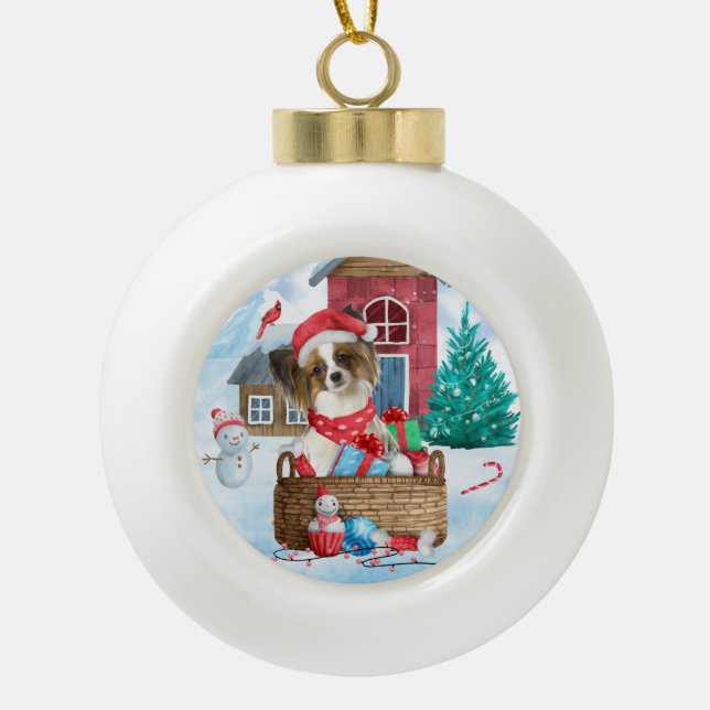 Papillon Dog In snow Christmas Dog House Ceramic Ball Christmas Ornament (Front)