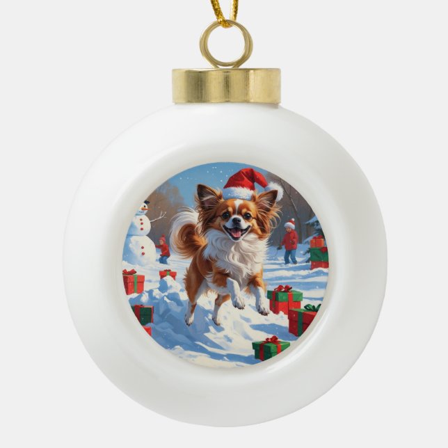 Papillon Dog Running in Snow with Christmas Hat Ceramic Ball Christmas Ornament (Front)