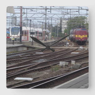 Passenger Trains arriving at railway station clock
