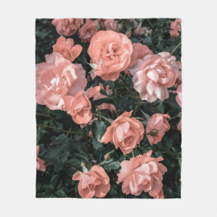Pastel pink roses growing in the garden in soft li fleece blanket