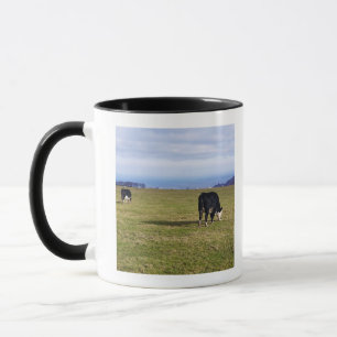 Pastoral scene of cows in field overlooking mug