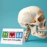 Peace Love Orthopaedics Holiday Card<br><div class="desc">Peace Love Orthopaedics present. A cute Christmas gift for an orthopaedic surgeon or orthopaedist who works with the musculoskeletal system and patients who need shoulder and hip surgery. A peace sign,  heart,  and a skeleton to show the bones of the speciality.</div>
