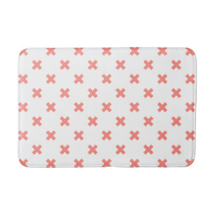 Peach cross stitches on white bath mat