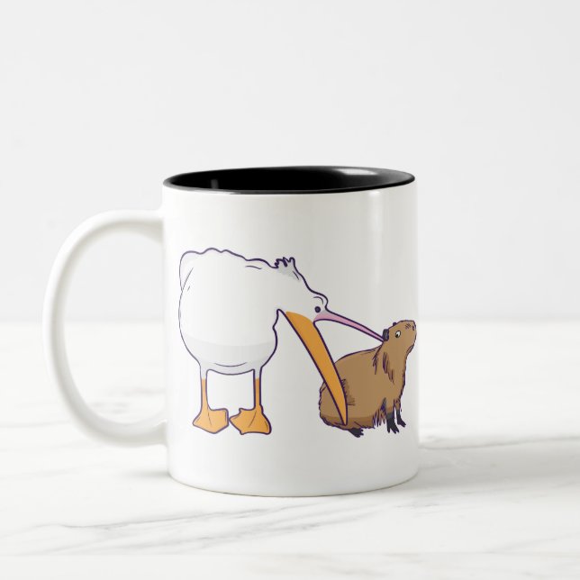 Pelican Tries to Eat Capybara Funny Cute Kawaii Two-Tone Coffee Mug (Left)