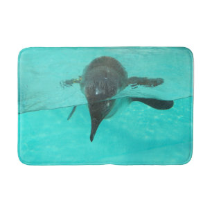 Penguin diving in blue water on a bath mat