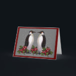 Penguins In Snow: Couple Christmas: Holly: Art Holiday Card<br><div class="desc">The words inside this card are customisable.  Two penguins stand face to face in falling snow,  with holly and berries at their feet.  A grey background sets off the scene,  created using my oil pastel artwork.</div>
