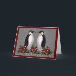 Penguins In Snow: Couple Christmas: Holly: Art Holiday Card<br><div class="desc">The words inside this card are customisable.  Two penguins stand face to face in falling snow,  with holly and berries at their feet.  A grey background sets off the scene,  created using my oil pastel artwork.</div>