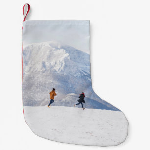 People having fun and running in mountains on the small christmas stocking