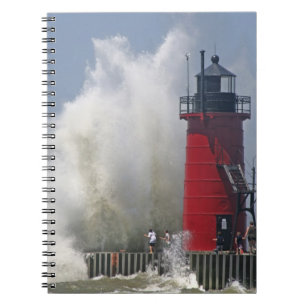 People on jetty watch large breaking waves in notebook