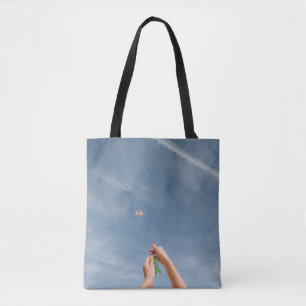 Person flying kite in the morning tote bag