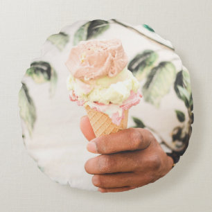 Person holding ice cream cone with three flavors o round cushion