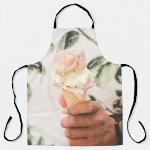 Person holding ice cream cone with three flavours  apron