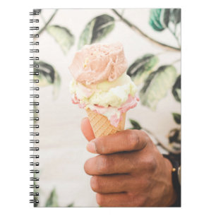Person holding ice cream cone with three flavours notebook