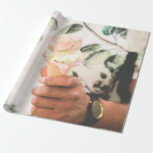 Person holding ice cream cone with three flavours  wrapping paper