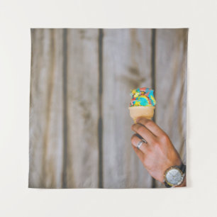Person holding multicolored ice cream tapestry