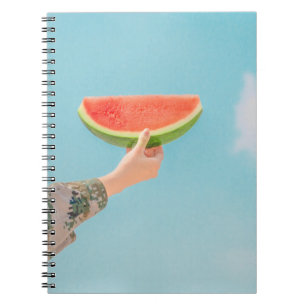 Person holding sliced watermelon notebook