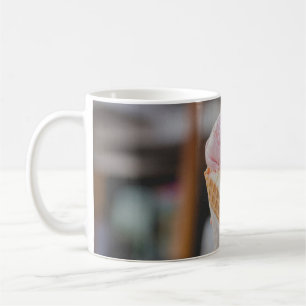 Person holding strawberry ice cream coffee mug