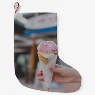 Person holding strawberry ice cream small christmas stocking
