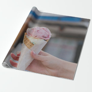 Person holding strawberry ice cream wrapping paper