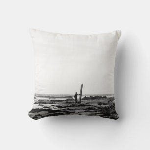 PERSON HOLDING SURFBOARD NEAR BODY OF WATER CUSHION