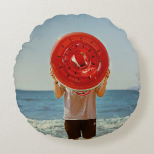 Person holding watermelon-themed inflatable ring round cushion
