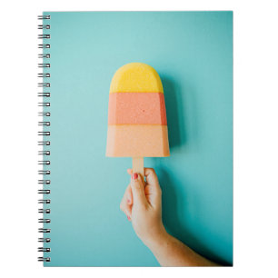 Person holding yellow and brown ice cream cone notebook