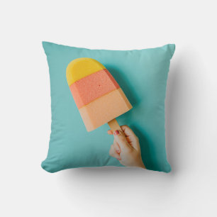 Person holding yellow and pink popsicle cushion