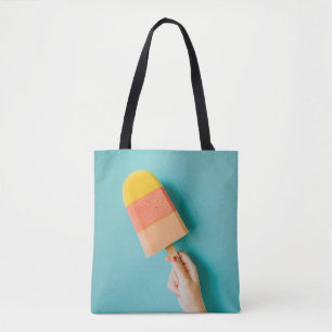 Person holding yellow and pink popsicle tote bag