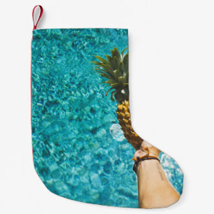 Person holding yellow pineapple small christmas stocking
