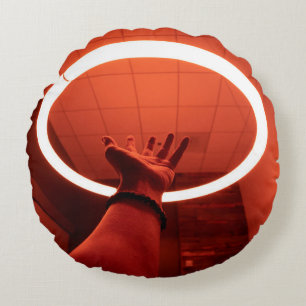 PERSON REACHING ROUND TURNED-ON FLUORESCENT LAMP I ROUND CUSHION