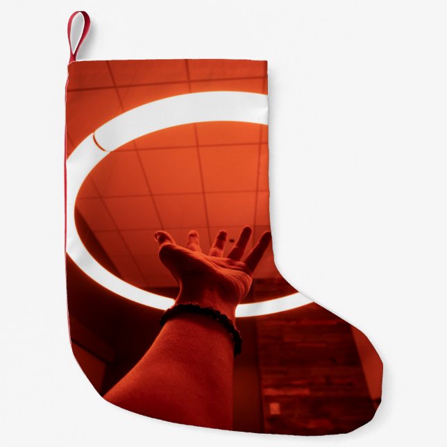 PERSON REACHING ROUND TURNED-ON FLUORESCENT LAMP I SMALL CHRISTMAS STOCKING (Front)