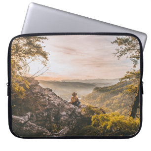 PERSON STANDING ON CLIFF NEAR TREE ON MOUNTAIN LAPTOP SLEEVE