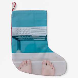 Person standing on swimming pool ladder small christmas stocking