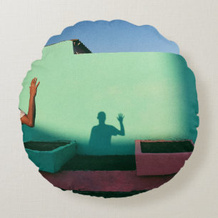 Person waving reflecting shadow on teal wall paint round cushion