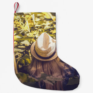 Person wearing white hat beside sunflower fields small christmas stocking