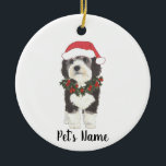 Personalized Bernedoodle Red and Green Christmas Ceramic Tree Decoration<br><div class="desc">I am in love with this beautifully detailed watercolor illustration of a grey, black, and white bernedoodle or sheepadoodle on an ornament with a sweet santa hat and red and green holly wreath outfit! Personalize these pastel ornaments and make the nice list this year! For the perfect presents, pair it...</div>