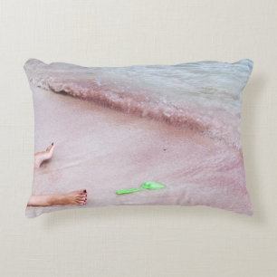 Person's foot beside green shovel on seashore decorative cushion