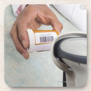 Pharmacist scanning pill bottle with a barcode coaster