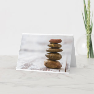 Pile of dark coloured stones on white background card